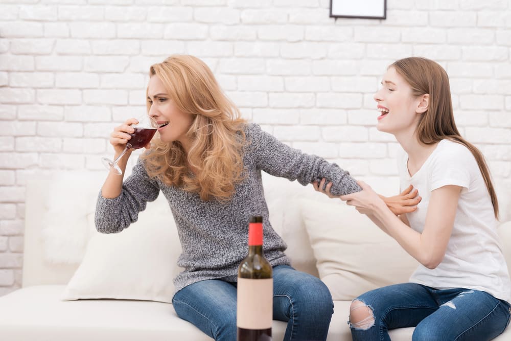 young adult stopping her mom with alcohol addiction problems