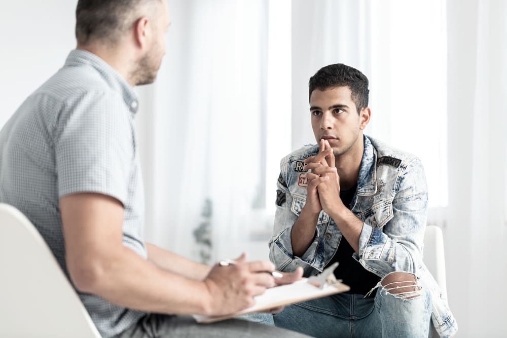 man talking to a psychologist about his mind, body, spirit addiction therapy