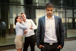 people at the back of a depressed man showing lack of empathy