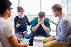 a man having a hard time in group therapy because he doesn't have his addiction recovery goals