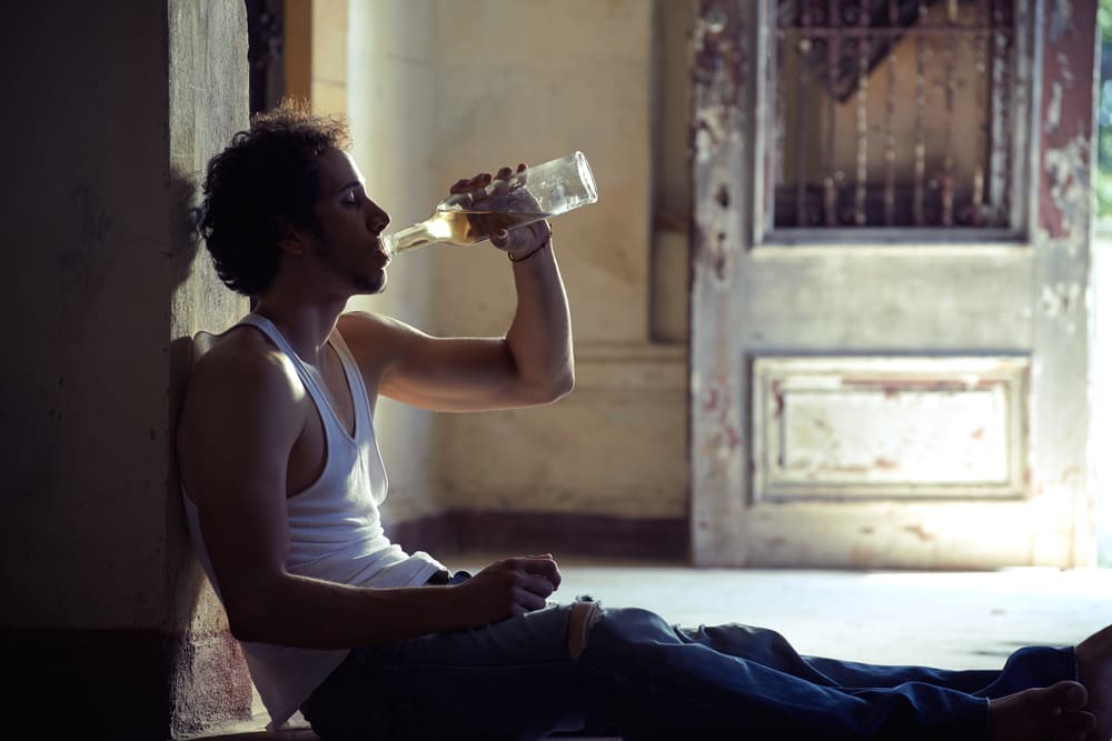 man drinking alcohol alone at home