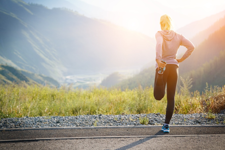 Stretching before walking meditation in nature at sunrise