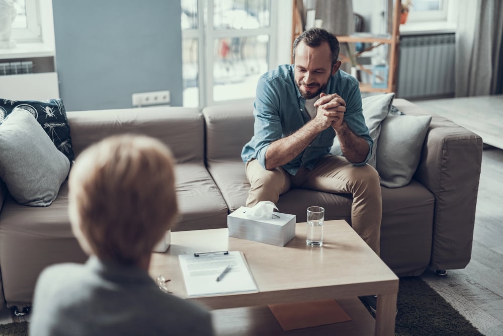 man discussing his aftercare services with his therapist