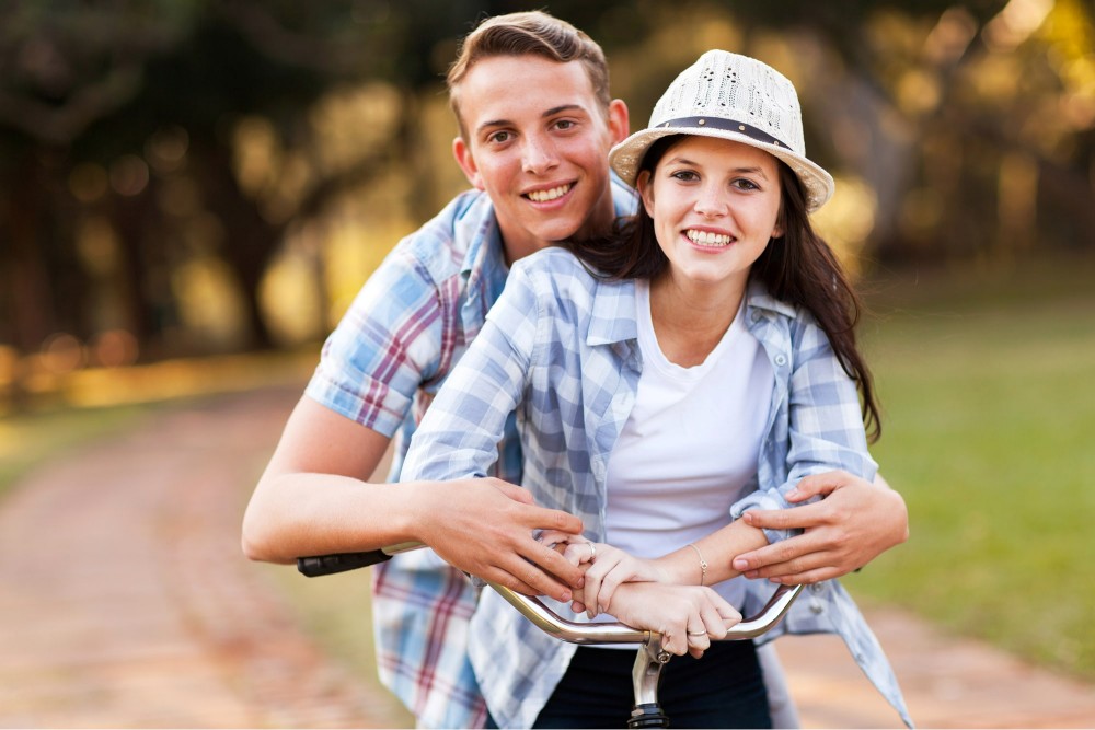 a smiling, young man and woman, free from cocaine addiction, riding bicycles