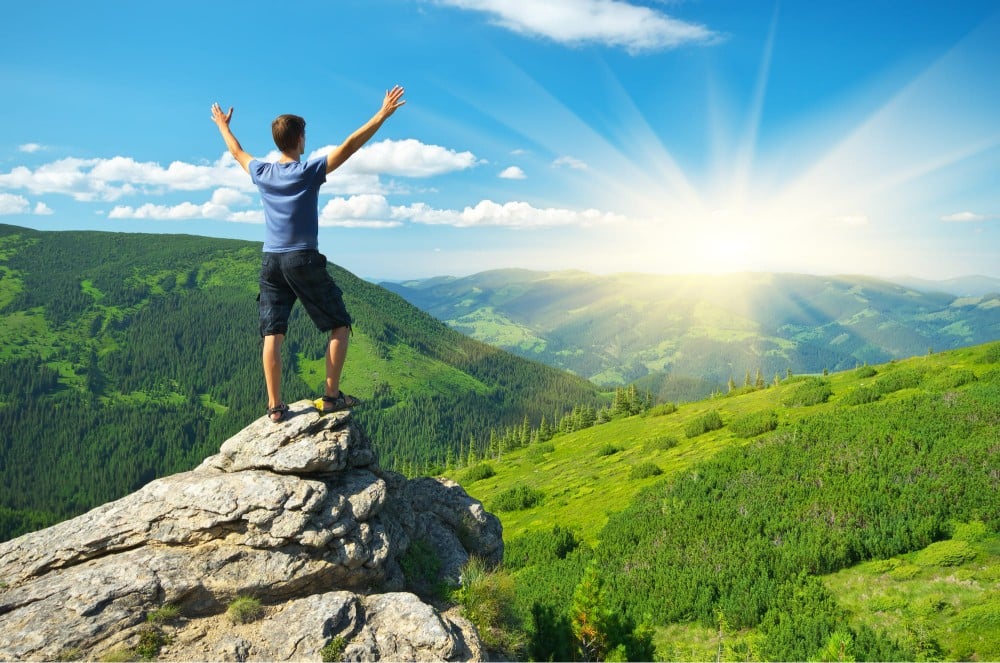 Man on top of a rock showing sign of recovery