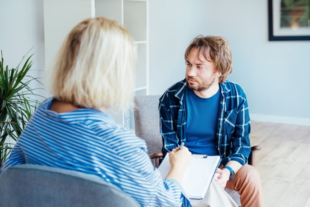  Man with emotional problems consulting professional therapist