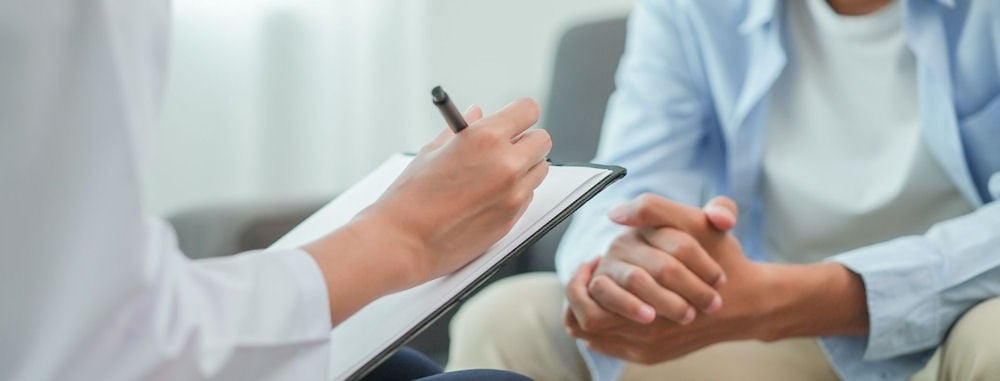 Young man consulting with doctor taking notes about addiction to anti-anxiety medication