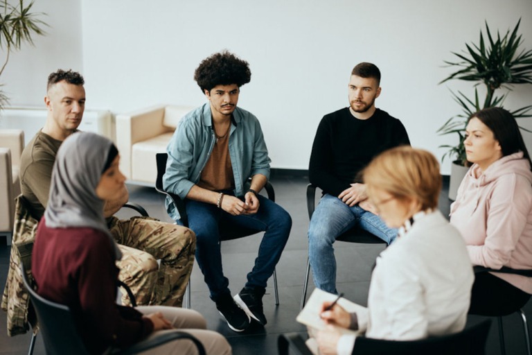 Mixed gender addiction recovery group discussing treatment options for addiction