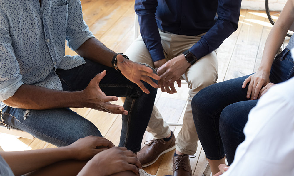 hands of individuals in group therapy