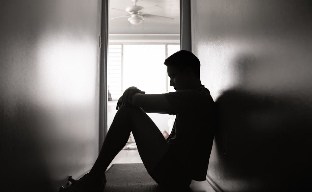 Silhouette of man sitting in a hallway