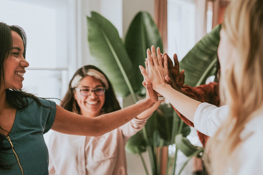 Women in support group doing group high-five.